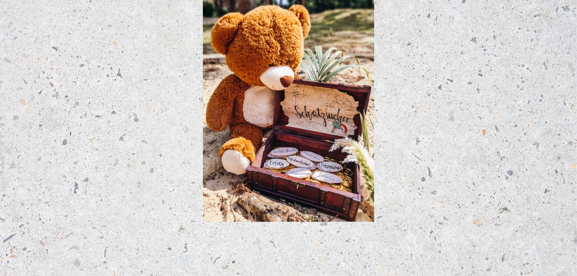 Das Bild zeigt einen Plüsch-Teddybär, der neben einer kleinen Schatzkiste sitzt.