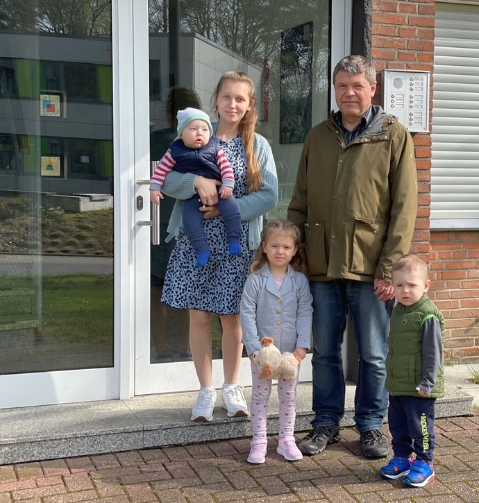 Das Bild zeigt eine Mutter und ihre drei Kinder, die aus der Ukraine kommen und mit einem Kollegen der LWL-Klinik Marl vor einem Gebäude stehen.